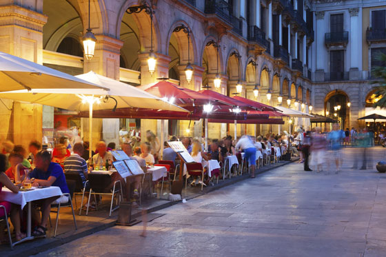 A plaza full of diners at dinner enjoying the slow, post-meal conversation, illustrating how cultural do's and taboos vary by country. (Image © JackF / iStock)