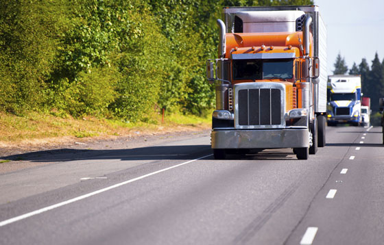 An 18-wheeler truck driving on the highway, illustrating how adventure cycling on Mexican toll roads changes perspectives (Image © iStock/vitpho).