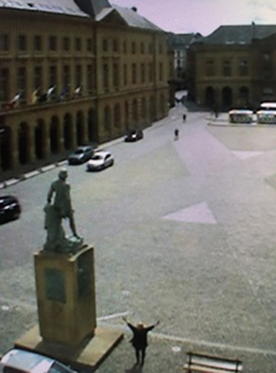 Small black figure in the Place d'Armes in Metz, virtual wanderlust via webcam. (Image courtesy of the city of Metz.)