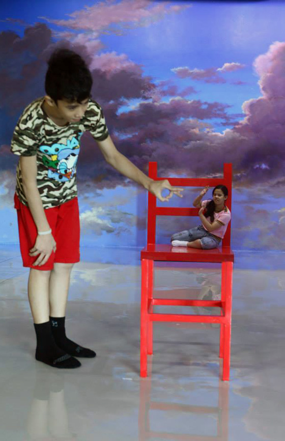Boy appearing out of proportion looks a smaller person in large chair in the 3D interactive painting, providing rich opportunities for selfies at the 3D interactive Art in Island Museum in the Philippines. (Photo courtesy of Art in Island Museum.)