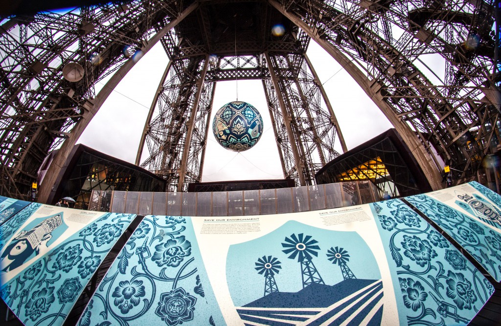 Shepard Fairey's Earth Crisis sphere suspended from Eiffel Tower, an art work by one of the global citizens focused on climate change. (Image courtesy of Galerie Itinerrance.)