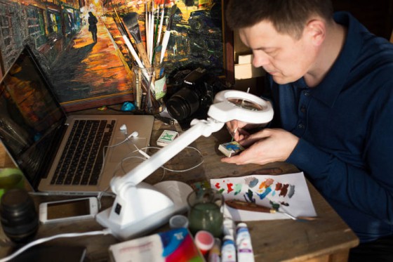 Salavat Fidai in his studio, working on pencil lead art and miniatures that provide travel inspiration for his fans. (Image courtesy of Salivat Fidai.)