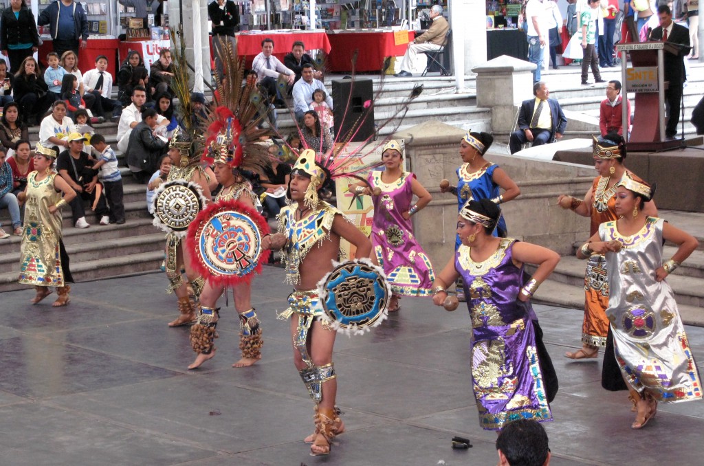 Traditional dancers dressed with feather headdresses, showing crossing cultures of Mexican tradition. (image © Eva Boynton)