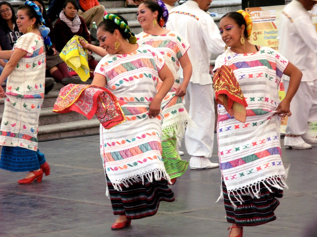 Women and men dancing in white and twirling scarves, showing Peruvian and Chilean influences on traditional Mexican dances. (Image © Eva Boynton)