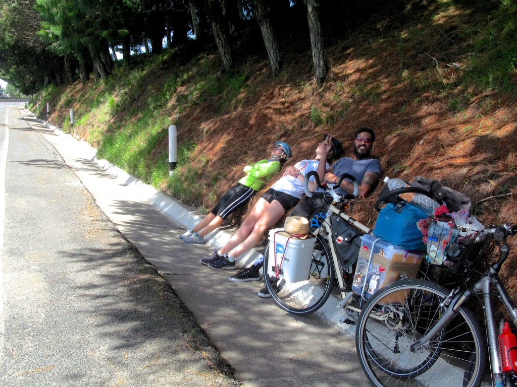Three cyclists resting in the shade during an adventure cycling tour along Mexican toll roads, showing that shade is a survival essential. (Image © Eva Boynton)