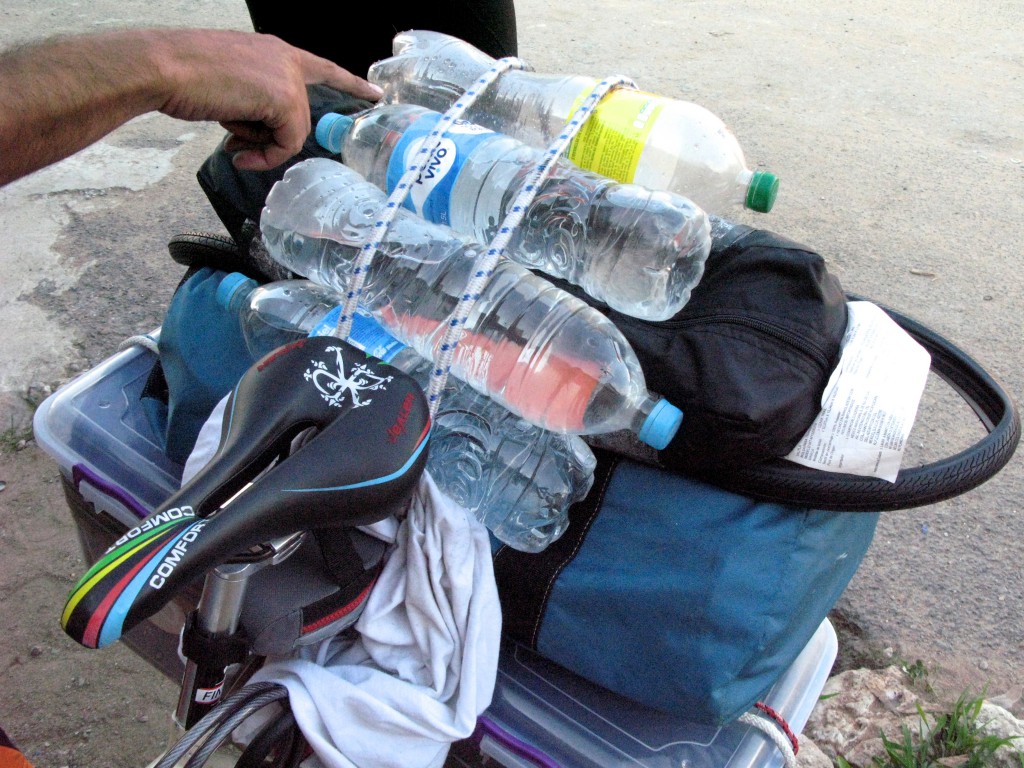 Water bottles strapped onto a bicycle, showing a survival essential for adventure cycling along the toll roads of Mexico. (Image © Eva Boynton).