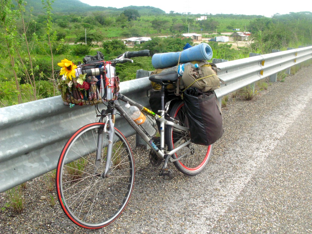 A travel bicycle parked on the side of a Mexican toll road during an adventure cycling experience, showing the how the simple things are the survival essentials. (Image © Eva Boynton)