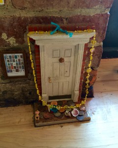 A miniature fairy door set into the baseboard of the Sweetwater Café in Ann Arbor, Michigan, illustrating a beloved element of the coffee culture that invites people to slow down and see things differently. (Image © Joyce McGreevy)