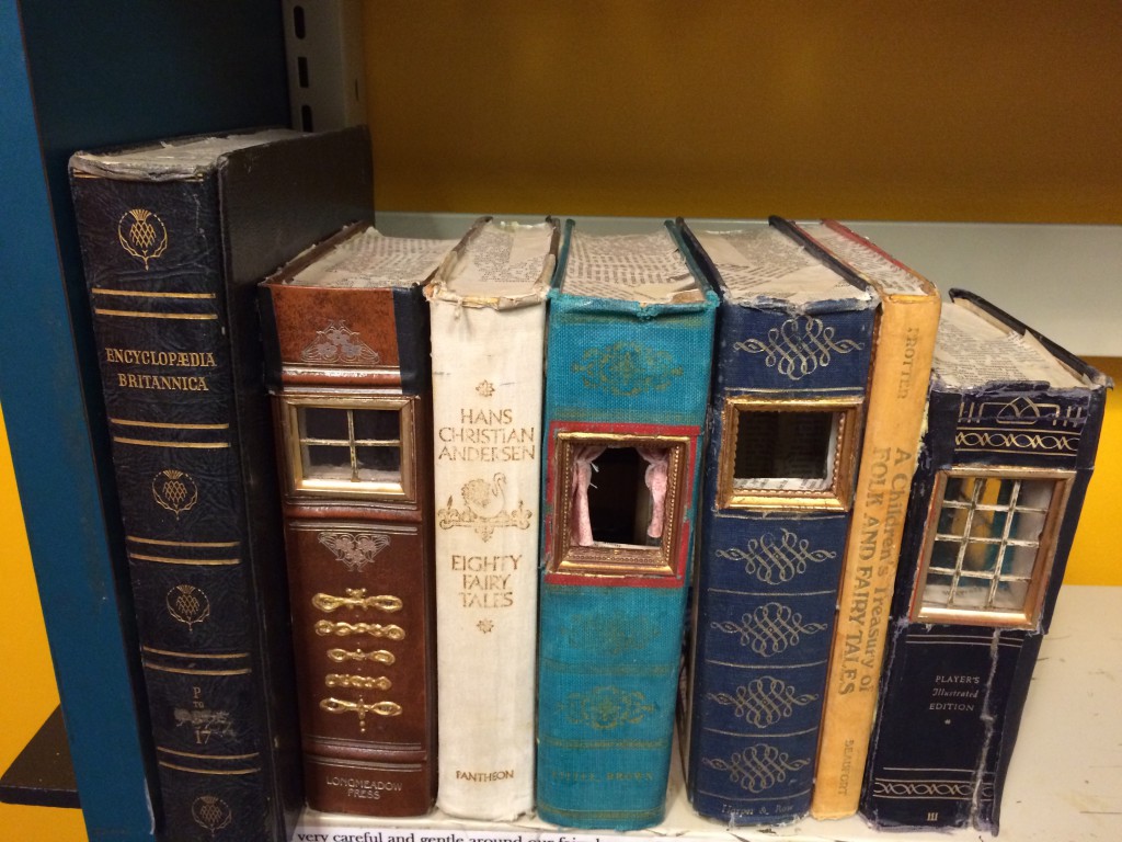 Fairy houses hidden within books at the public library in Ann Arbor, Michigan, inviting people to see things differently in miniature. (Image © Joyce McGreevy)