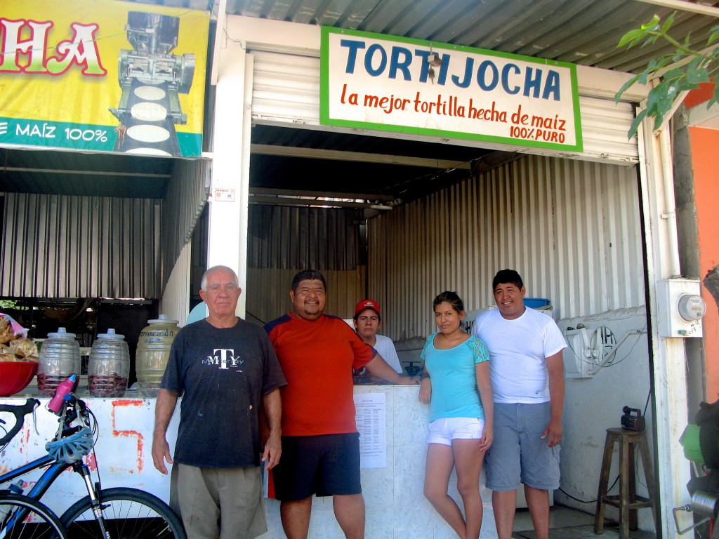 Jocha and his family standing in front of their tortilla shop, illustrating the connection between corn tortillas and Mexico's cultural heritage and traditions. (Image © Eva Boynton).