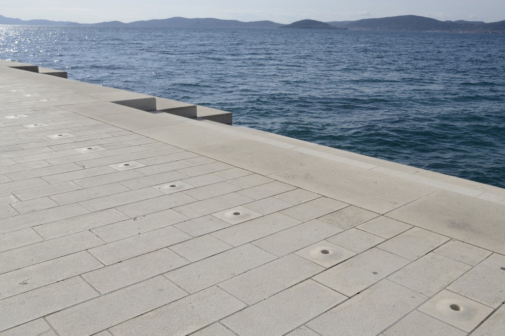 Holes in the sidewalk where the music is channeled in the sea organ of Zadar, Croatia, travel inspiration for music and nature lovers. (Image © Meredith Mullins.)