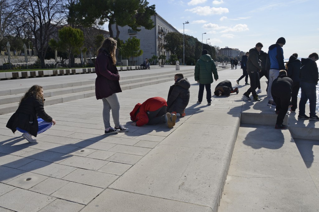 Children listen to the sea organ in Zadar, Croatia, travel inspiration for all ages. (Image © Meredith Mullins.)