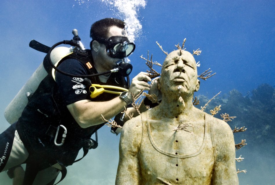 Artist Jason deCaires Taylor scuba dives and plants coral in his sculptures in the underwater museum, showing innovations by artist and ocean. (image © Jason deCaires Taylor).