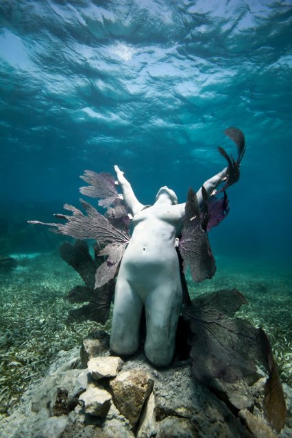 A sculpture of a woman with coral growing from her sides in the underwater museum by Jason deCaires Taylor, showing innovations of artist and ocean. (image © Jason deCaires Taylor)