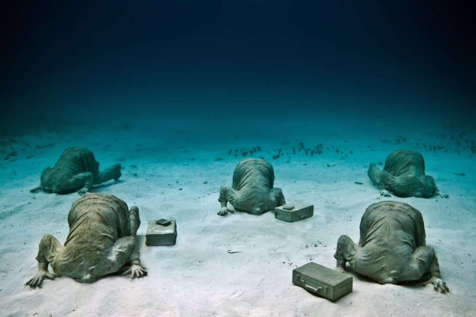 Sculptures of bankers with their heads in the sand in the underwater museum of Jason deCaires Taylor, showing innovations by artist and ocean. (image © Jason deCaires Taylor).