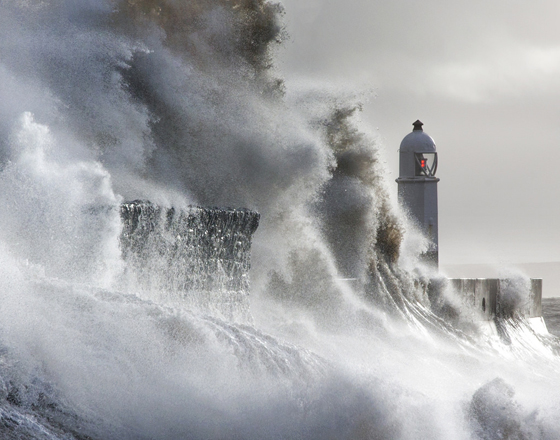 Waves hitting the barrier at the Porthcawl lighthouse in Wales, one of the most amazing places on earth to photograph. (Image © Steven Garrington.)