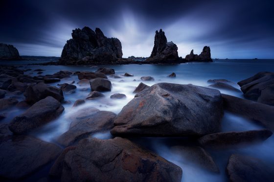 Rock formations into the water in France, landscape photography that provides a virtual journey and a celebration of Earth Day. (Image © Nicolas Rottiers.) 