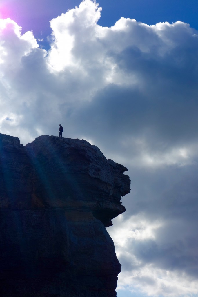 A hiker stares down from atop the Azure Window in Gozo, Malta, place Edward Lear visited with a traveler's wanderlust and one that inspired his wordplay and watercolor paintings. (Image by Joyce McGreevy)