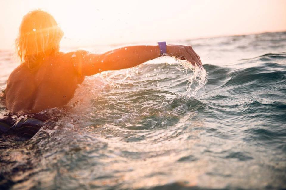 A surfer wearing shark repellent, showing how creative thinkers have found a solution (image © Josh Letchworth).