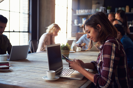 Interior Of Coffee Shop With Customers Using Digital Devices, showing the language of social media and cultural changes. (Image © Monkey Business Images/iStock.)