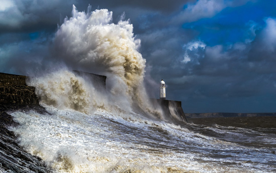 Giant wave over Porthcawl lighthouse, one of the amazing places on earth to photograph. (Image © D.W. Ryan/iStock.)
