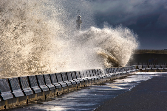 Waves crushing against a lighthouse barrier at Sunderland, Tyne and Wear, England, one of the most amazing places on earth to photograph. (Image cg Design Pics/Thinkstock.)