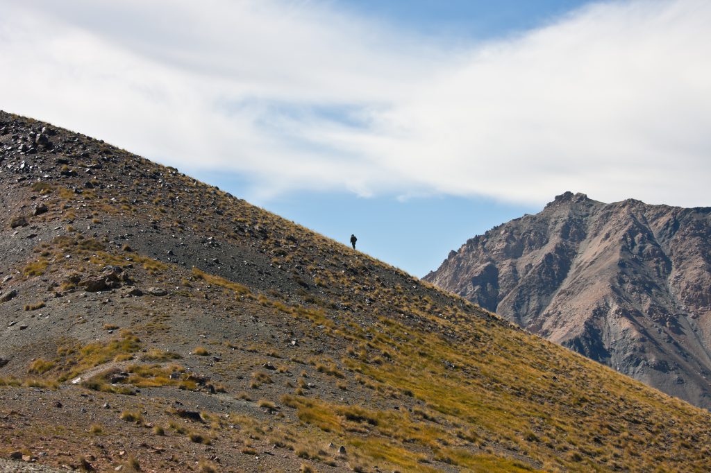 Hunter walking on a mountain, another traveler seeking travel inspiration along with Paul Salopek of the Out of Eden walk. (Image © Oner Enarih.)