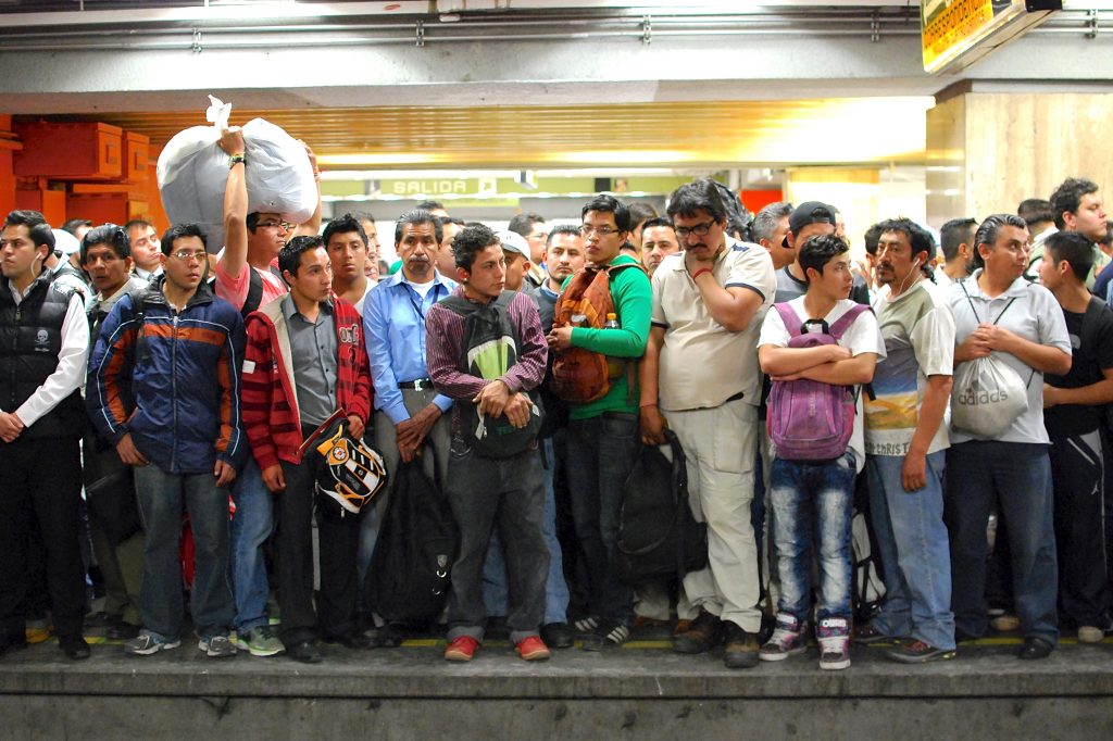 A crowd of men waiting for the metro in Mexico City, illustrating a safety issue for women, addressed by pink transportation in its work for women's rights and gender equality (image © Sergio Beristain).