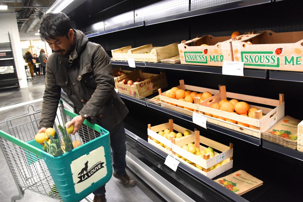 Man with shopping cart at La Louve, the new Paris food co-op that unites different cultures. (Image © Meredith Mullins.)