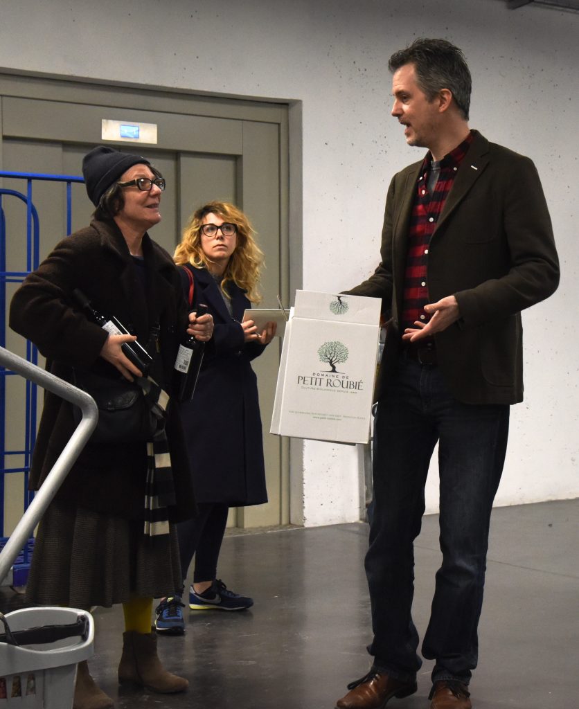 Three people discuss wine at the Paris food co-op La Louve, an experiment in the blending of different cultures. (Image © Meredith Mullins.)