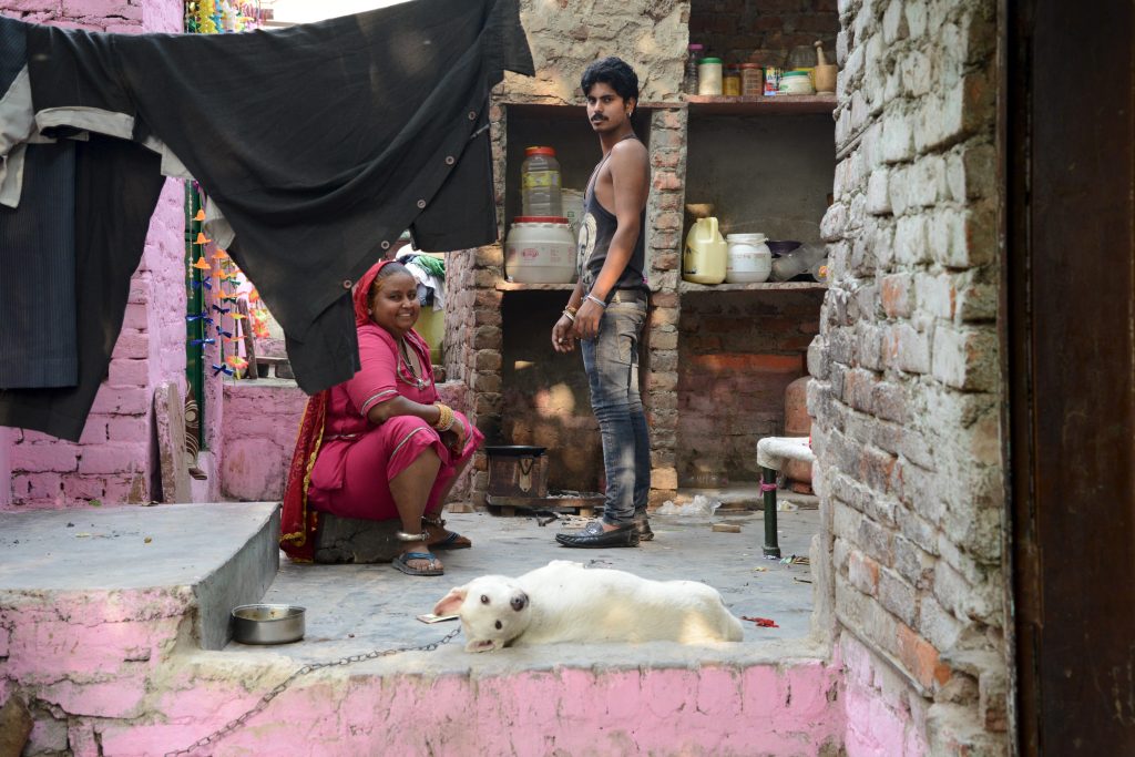 A home in the Kathputli Colony, with mother, son, and dog, showing cultural encounters in the slums of India. (Image © Meredith Mullins.)