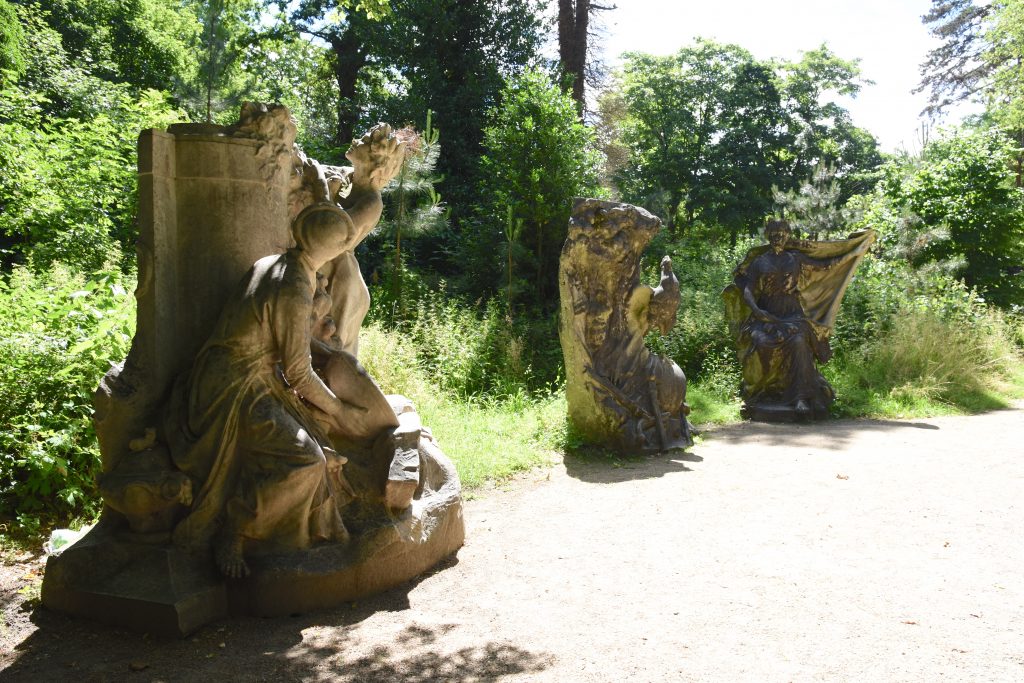 Three statues from the 1931 colonial exhibition at the Jardin d'agronomie Tropicale, one of the hidden gardens in Paris where visitors are traveling the world. (Image © Meredith Mullins.)