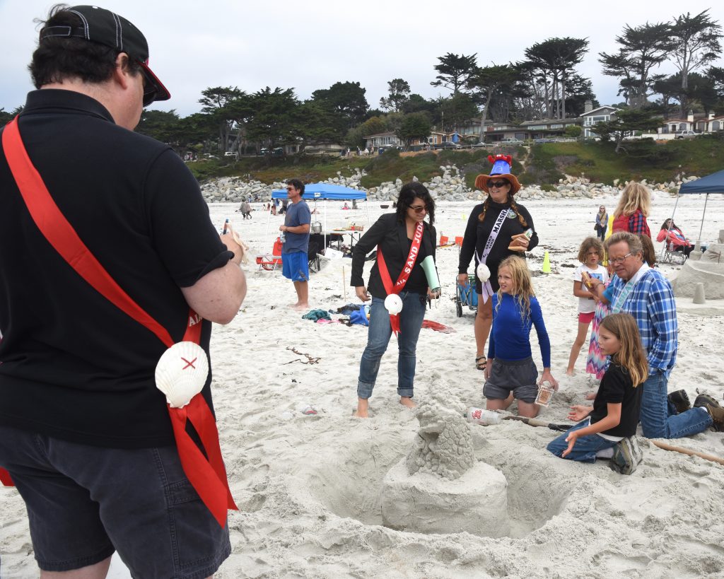 Judges reviewing a sand castle at the Great Carmel Sand Castle Contest, where entrants are discovering the art of sand sculpture. (Image © Meredith Mullins.)