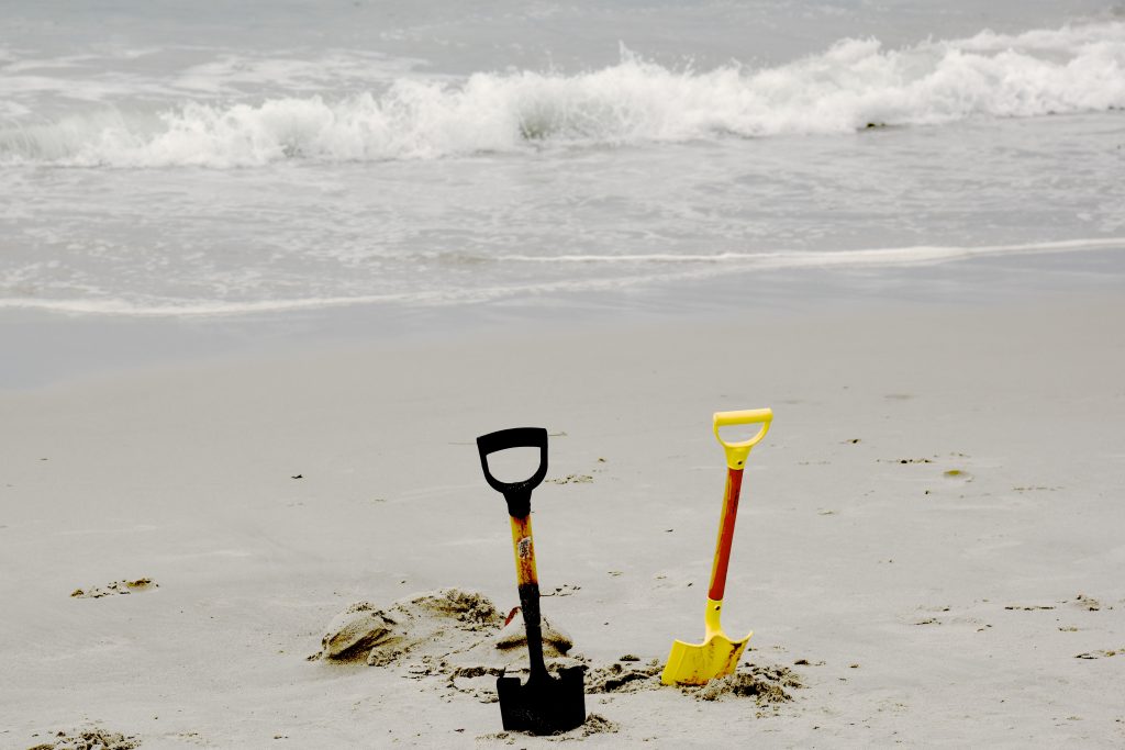 Shovels in the sad, the remnants of a sand sculpture at the Great Carmel Sand Castle Contest, discovering the art of sand sculptures. (Image © Meredith Mullins.)