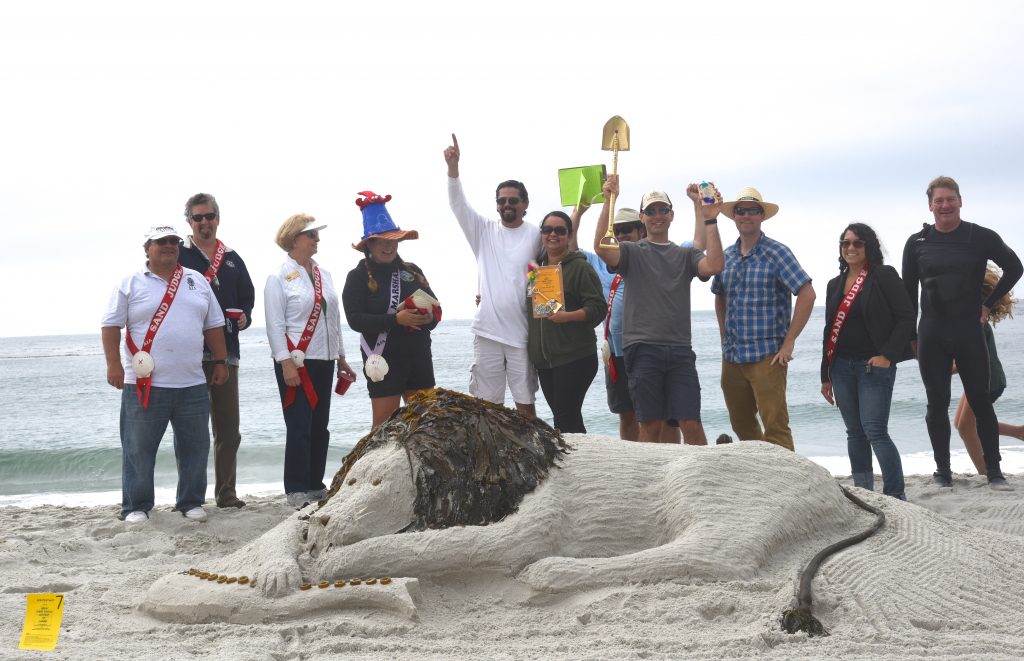 Winners and judges of the Great Carmel Sand Castle Contest of 2017, discovering the art of sand sculptures in the best possible way. (Image © Meredith Mullins.)