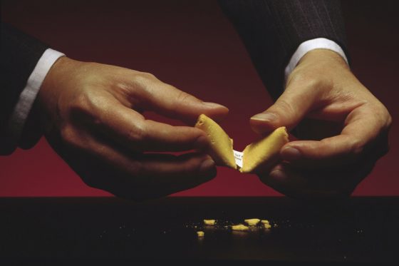 Man's hands opening fortune cookies, revealing proverbs and sayings that can change your life. (Image © Comstock/Stockbyte.)