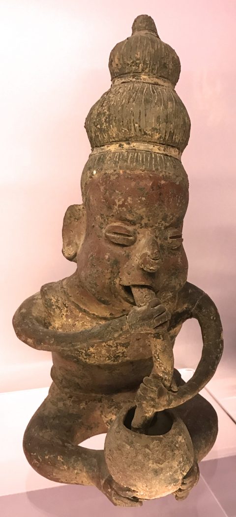 Wooden sculpture of man blowing air into cocoa bowl of hot chocolate, one of the fun facts about chocolate. (Image © Meredith Mullins.)