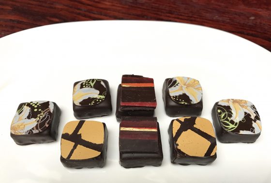 Pieces of artisanal chocolate from Josephine Vannier in Paris, showing cultural traditions of chocolate and fun facts about chocolate and the cocoa bean. (Image © Meredith Mullins.)