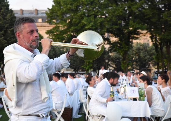 Horn player at the Paris Dîner en Blanc, enjoying the cultural traditions of the Dinner in White. (Image © Meredith Mullins.)