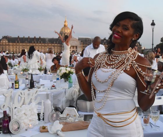 Woman with gold and silver beads at the Paris Dîner en Blanc in front of Invalides, enjoying the cultural traditions of the Dinner in White. (Image © Meredith Mullins.)