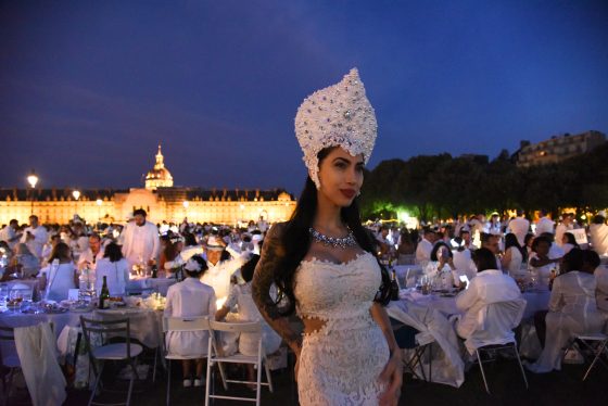 Woman in headers at the Paris Dîner en Blanc in front of Invalides, enjoying the cultural traditions of the Dinner in White. (Image © Meredith Mullins.)
