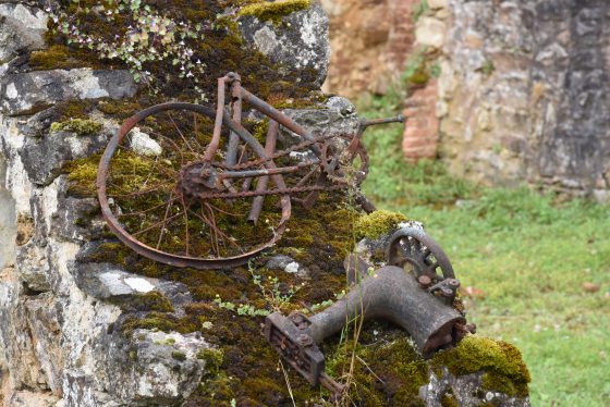 A rusted bike and sewing machine in Oradour-sur-Glane, an important part of the cultural history of WW II in France. (Image © Meredith Mullins.)