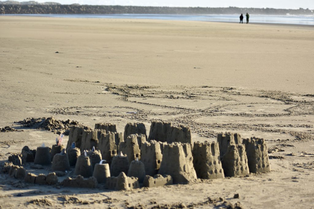 Sandcastles on the beach suggest the pleasure of savoring summer. (Image @ Joyce McGreevy)