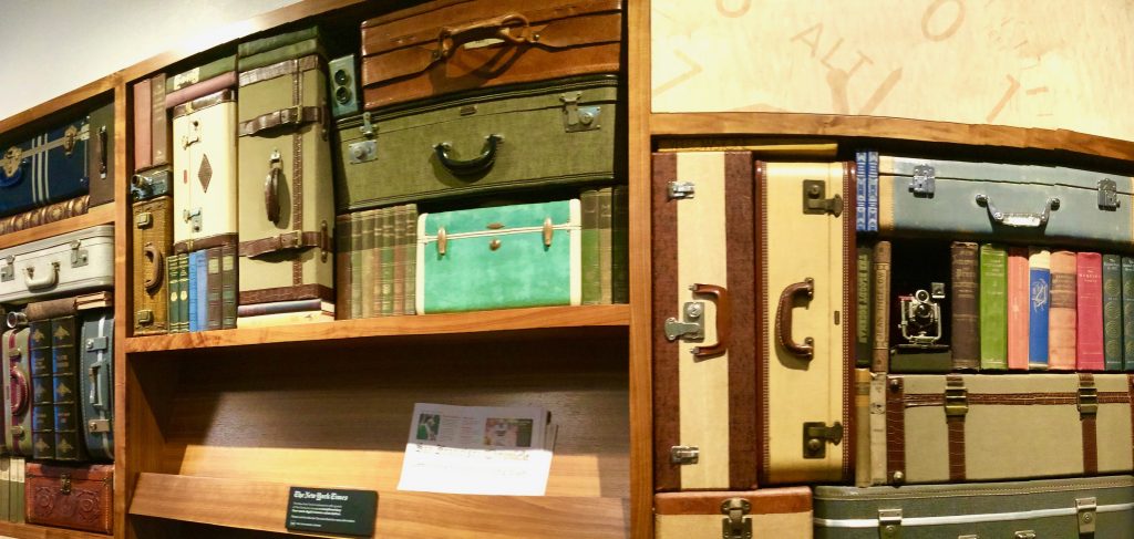 Vintage books and suitcases on display in San Francisco symbolize reading while traveling to distant places and times, through a wanderlust for words. (Image © Joyce McGreevy)