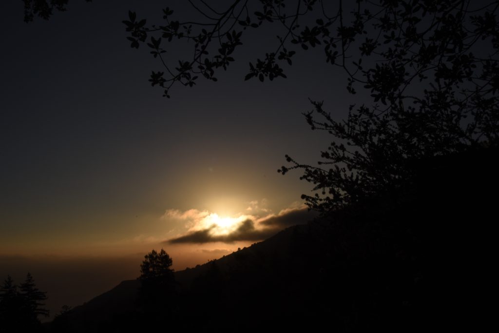 A golden sunset behind a cloud at the Big Sur New Camaldoli hermitage, a place for seeking silence and challenging the cultural traditions of Labor Day. (Image © Meredith Mullins.)