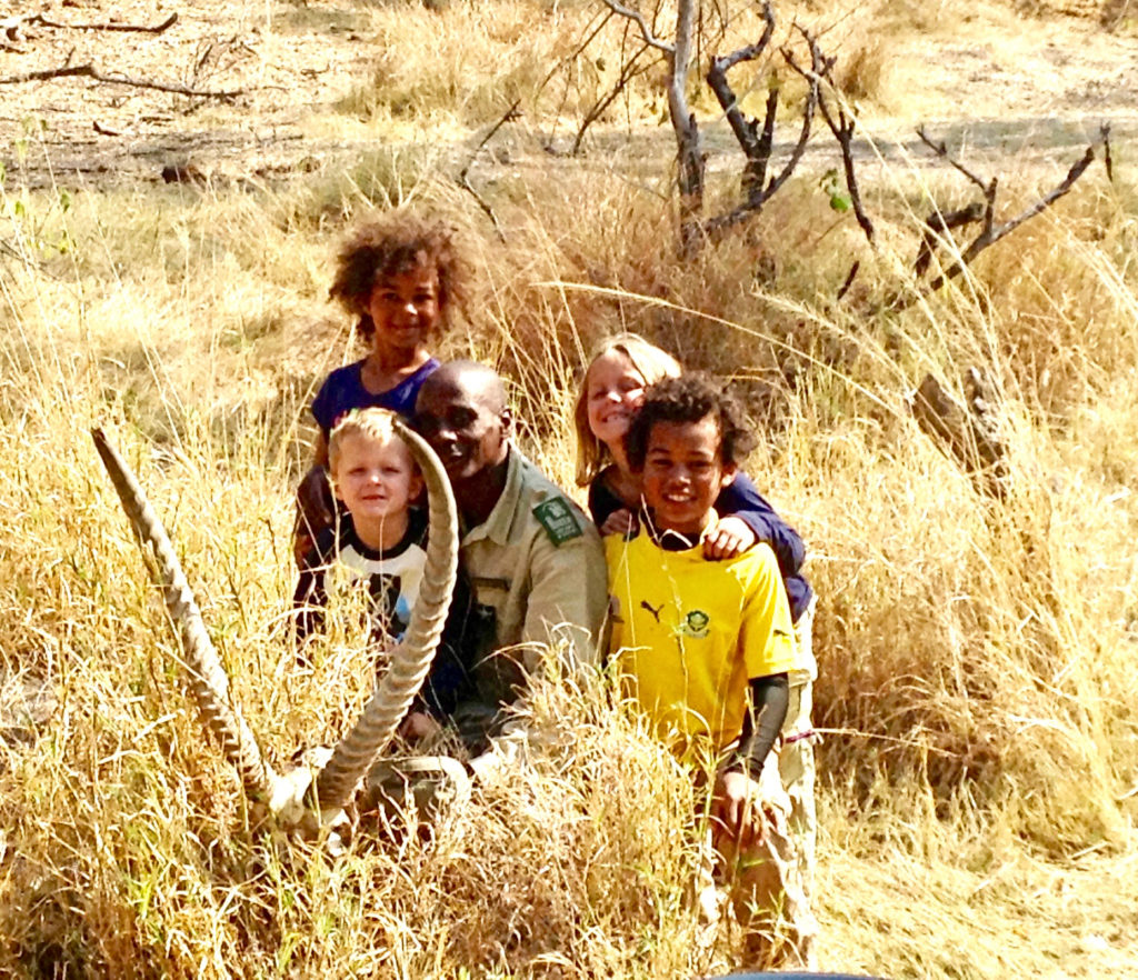 A portrait of happy children and local guide Tumeletso Setlabosha, also known as Water, shows that visiting Okavago Delta, Botswana, is a life-changing experience at any age. Image © Honor Teoudoussia