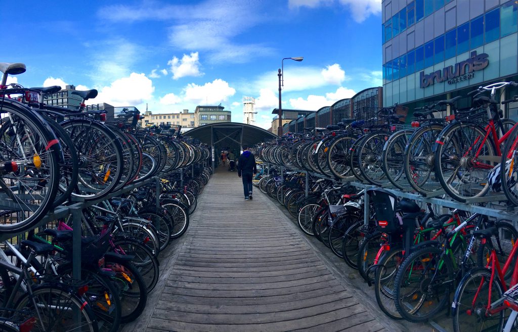 Hundreds of parked bikes in Aarhus, Denmark symbolize discoveries of alternatives to auto traffic and are a boon to urban peace and quiet. (© Joyce McGreevy)