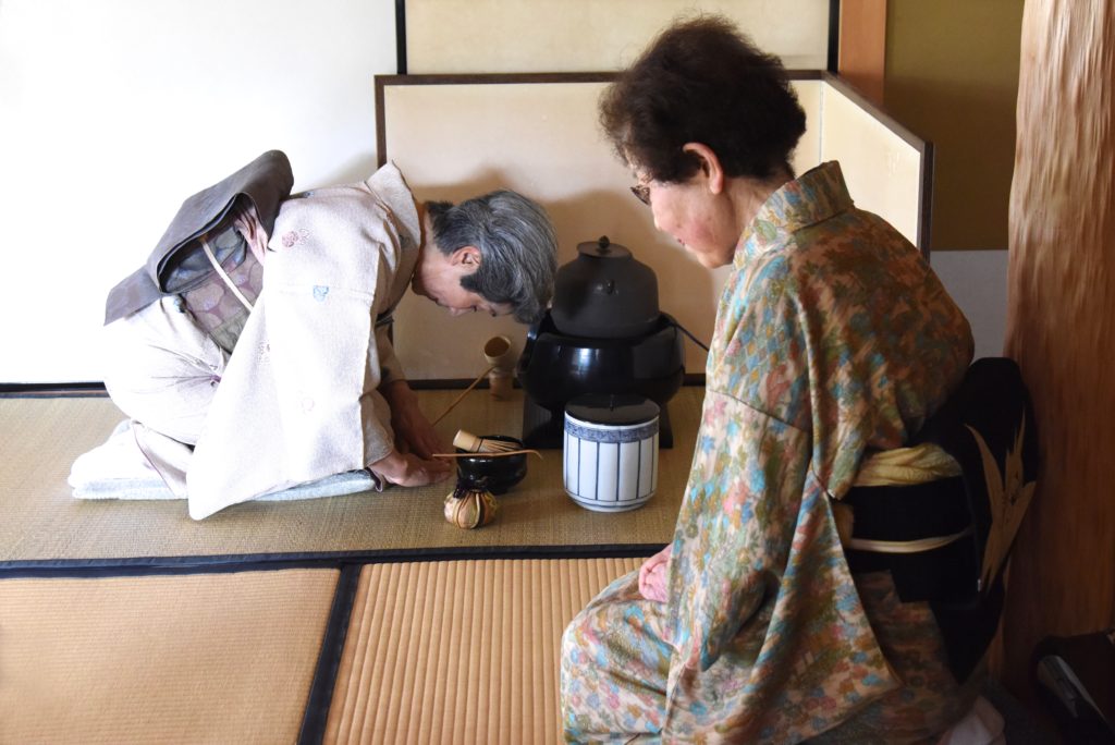 Japanese teacher Mrs. Matsui oversees a student in the art of the Japanese tea ceremony, showing the cultural traditions of Japan. (Image © Meredith Mullins.)