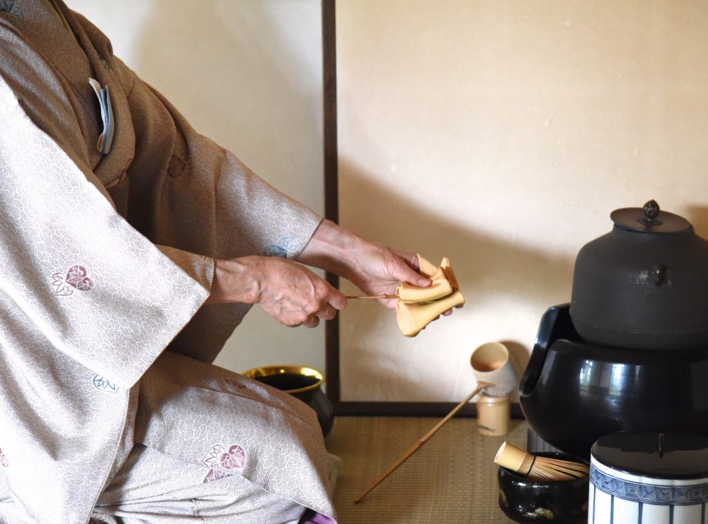 Japanese woman cleaning tea scoop for a Japanese tea ceremony, showing the cultural traditions of Japan. (Image © Meredith Mullins.)