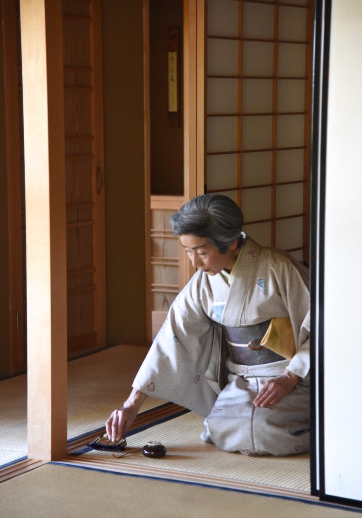 Japanese woman at door of tea room preparing for a Japanese tea ceremony, showing the cultural traditions of Japan. (Image © Meredith Mullins.)